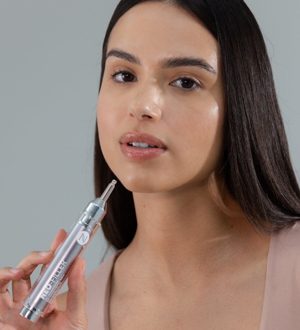 A woman applying Neo-FILLER to her cheek.